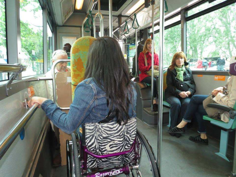 a girl travelling with wheelchair in a bus