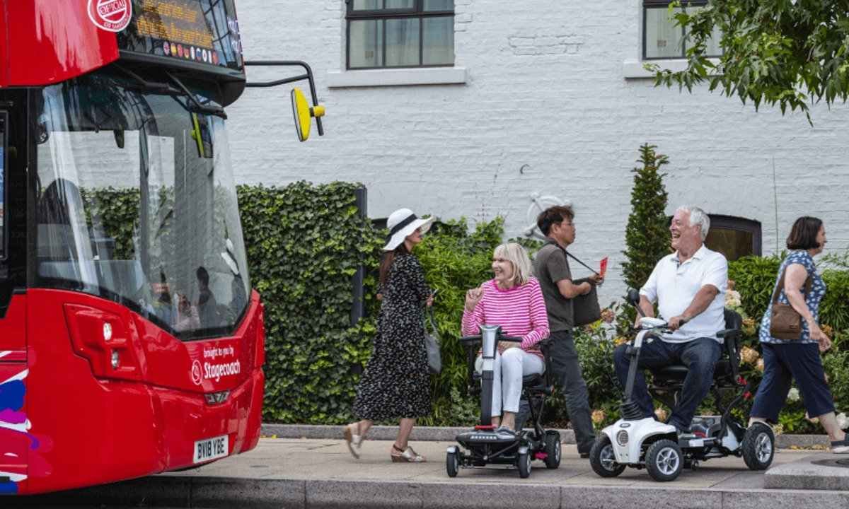 people using wheelchairs waiting for bus 